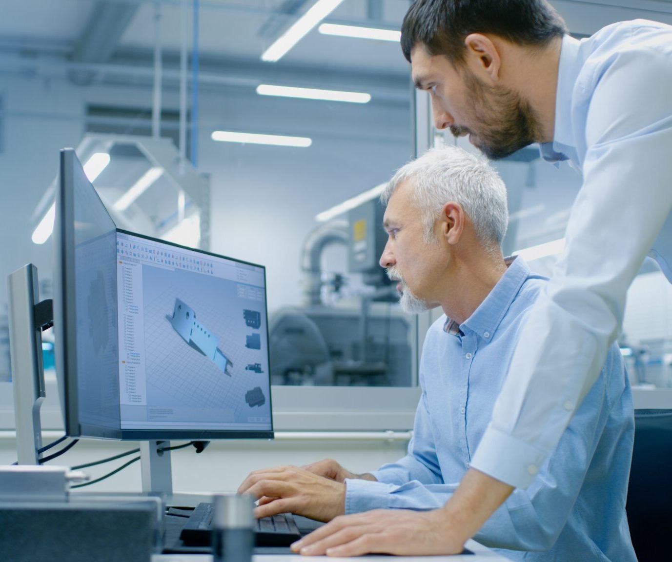 two engineers reviewing a CAD file for a plastic fabricated part