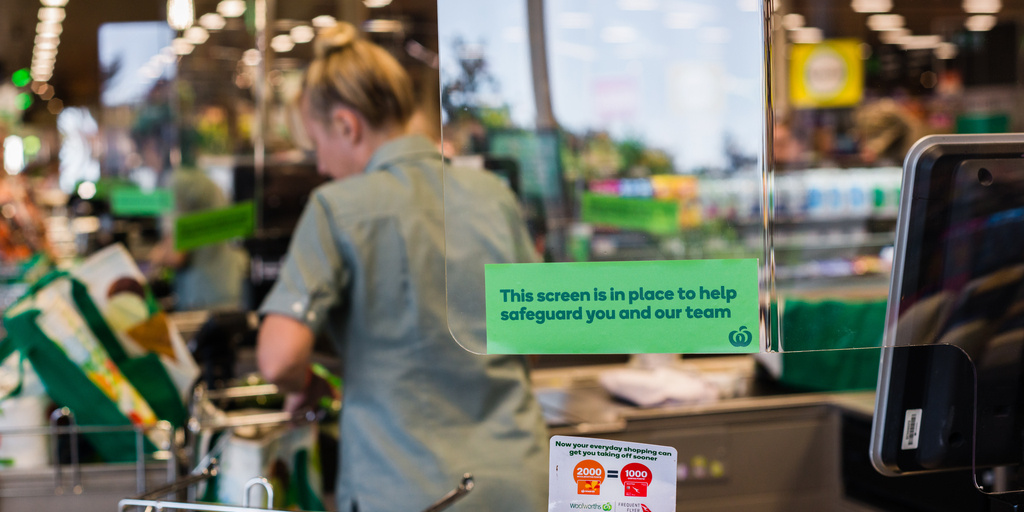 a sign in a store asking customers to keep a safe social distance