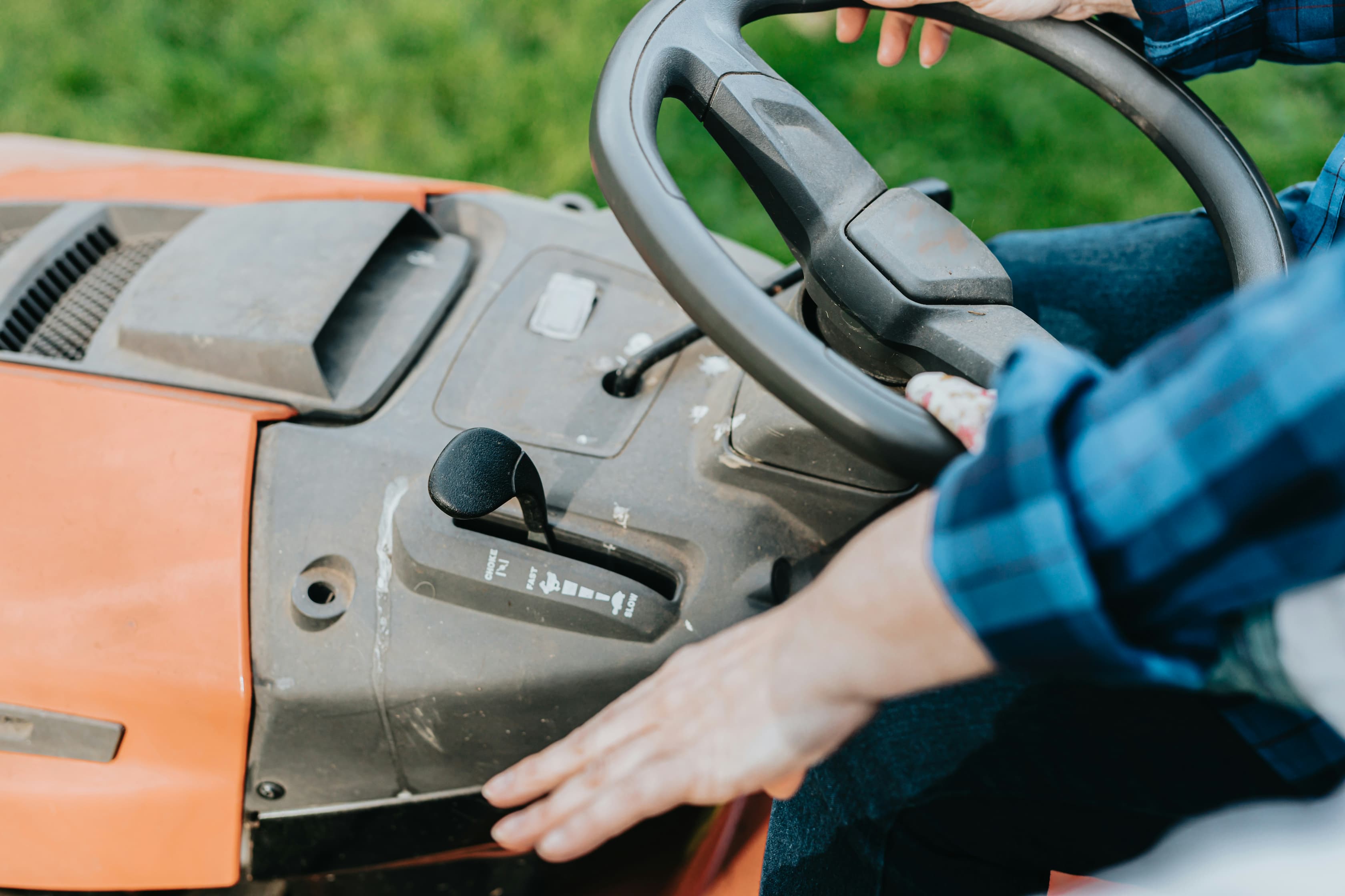 a close-up of a user on a riding lawn mower