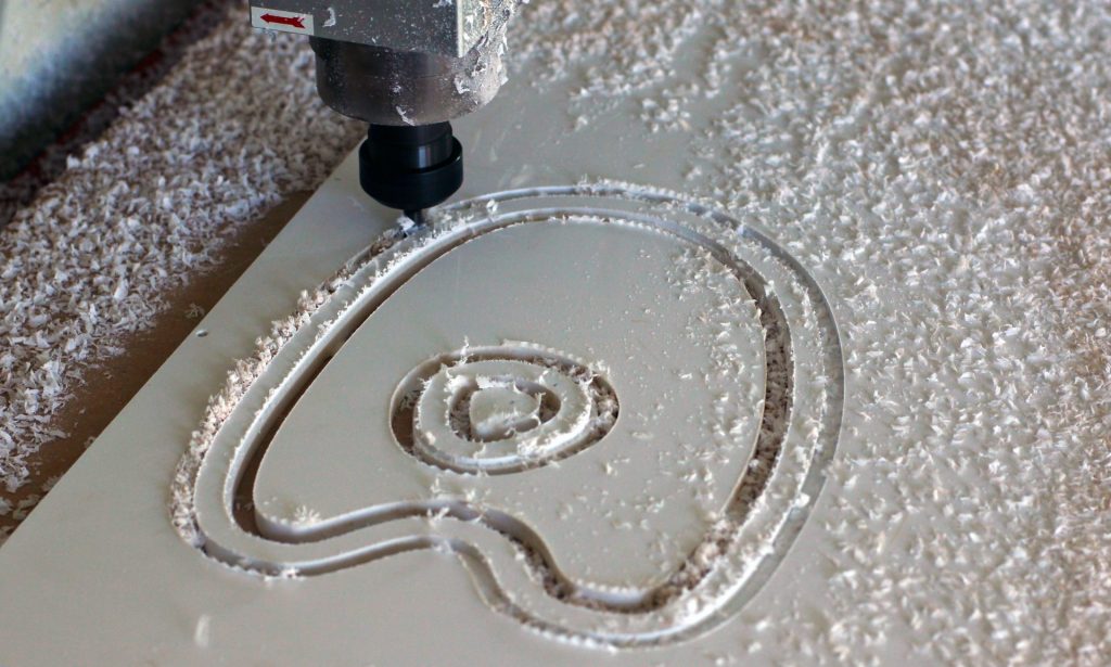 a close-up of a CNC router cutting plastic